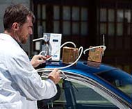 Technician measuring air quality in car